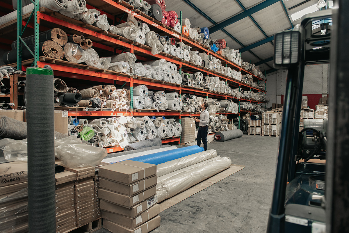 Manager checking his warehouse stock using a clipboard